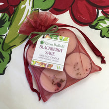 Load image into Gallery viewer, Packaged candles with a &#39;Green Daffodil&#39; label on a colorful fabric background