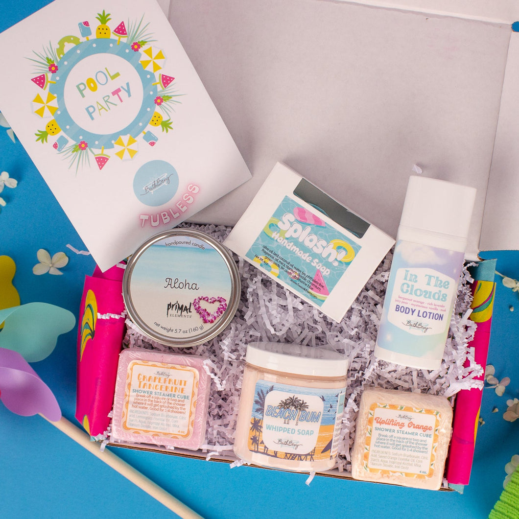 Assorted beauty products including a book, soap, and lotion in a box on a blue background.