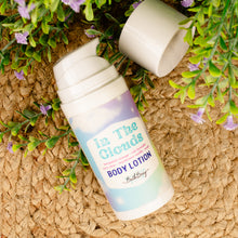 Load image into Gallery viewer, Body lotion bottle labeled &#39;In The Clouds&#39; on a woven surface with greenery