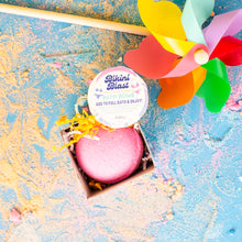 Load image into Gallery viewer, Pink bath bomb in a box with a colorful pinwheel on a textured blue and gold background