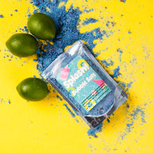 Load image into Gallery viewer, Bath bomb packaging with limes and blue powder on a yellow background