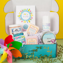 Load image into Gallery viewer, Gift box with bath and body products on a yellow background