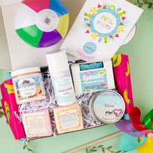 Load image into Gallery viewer, Gift box with beach-themed products including a beach ball and body care items on a light green background.