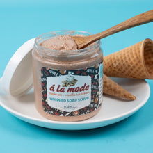 Load image into Gallery viewer, Jar of &#39;a la mode&#39; whipped soap scrub with a wooden spoon on a blue background