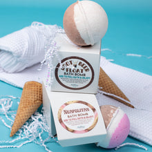 Load image into Gallery viewer, Bath bombs with their packaging on a blue background with ice cream cones and a towel.