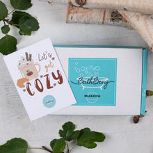 Load image into Gallery viewer, Bath bomb packaging with &#39;Let&#39;s get cozy&#39; card on a wooden surface with leaves.