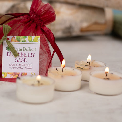 Candle packaging with lit candles on a neutral background